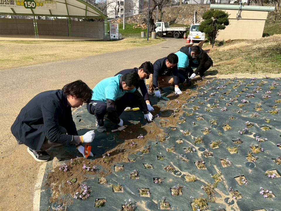 花壇に花を植えるメンバー