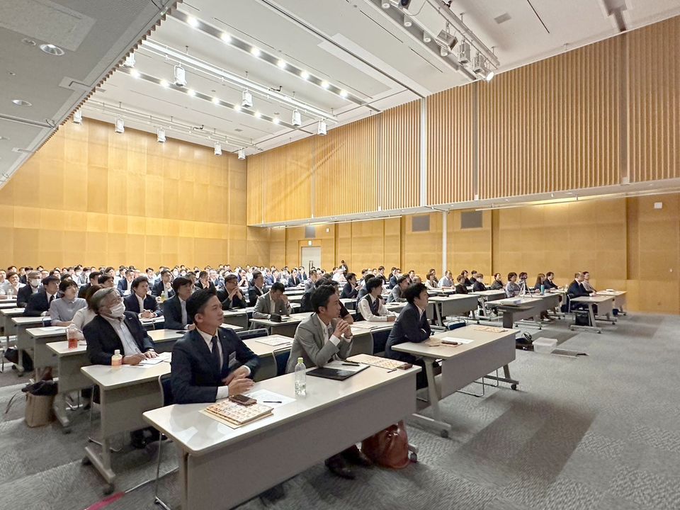 例会の会場で講演を聞く参加者
